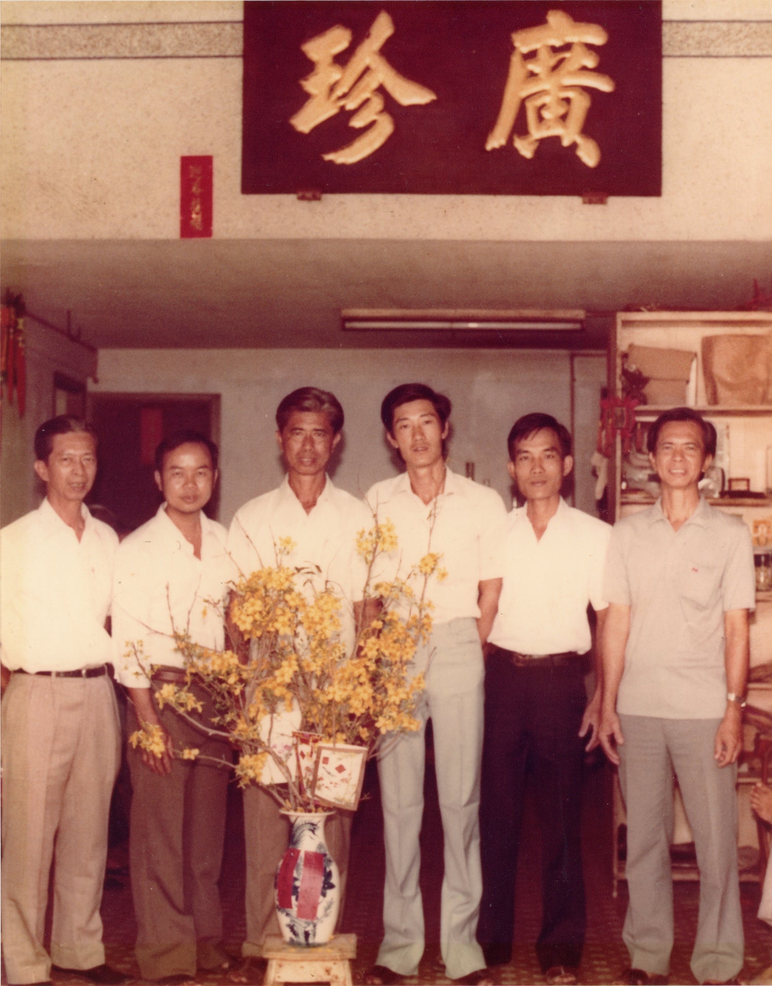 muoi tran and family friends in front of quang tran's name plate