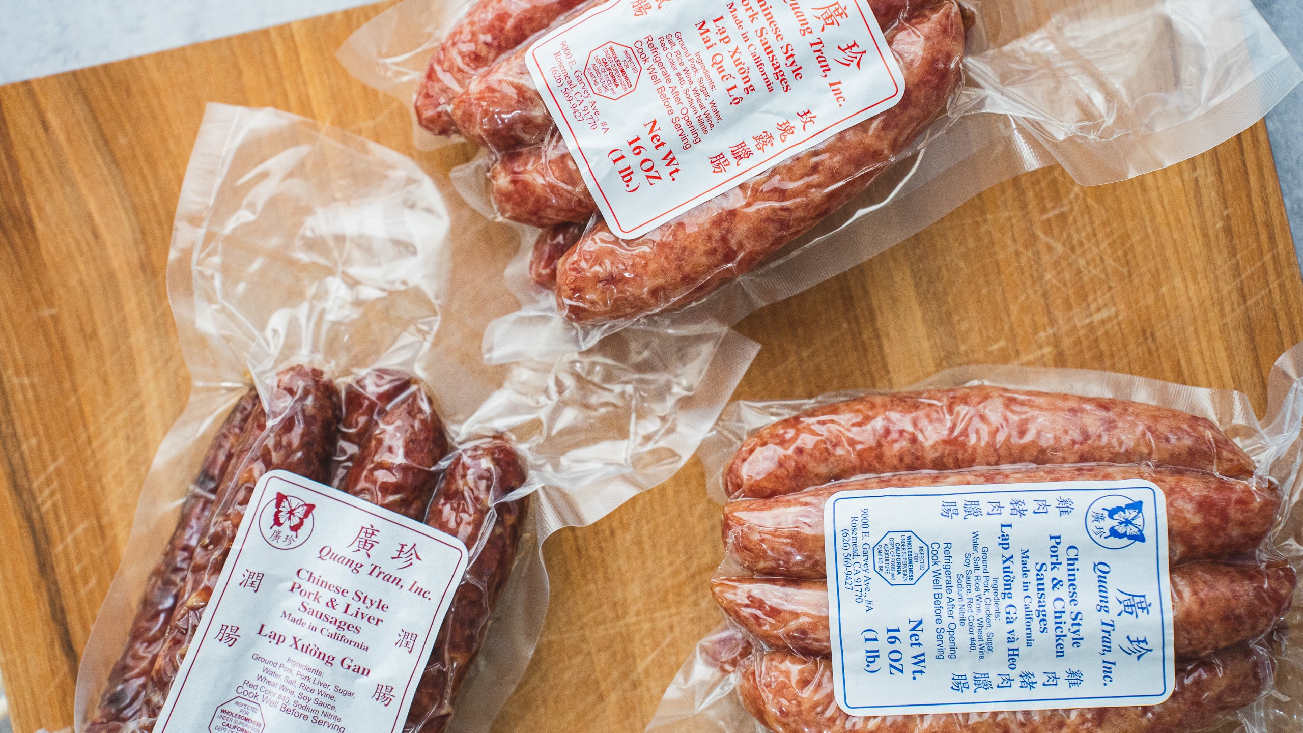 three packages of quang tran sausages displayed on cutting board